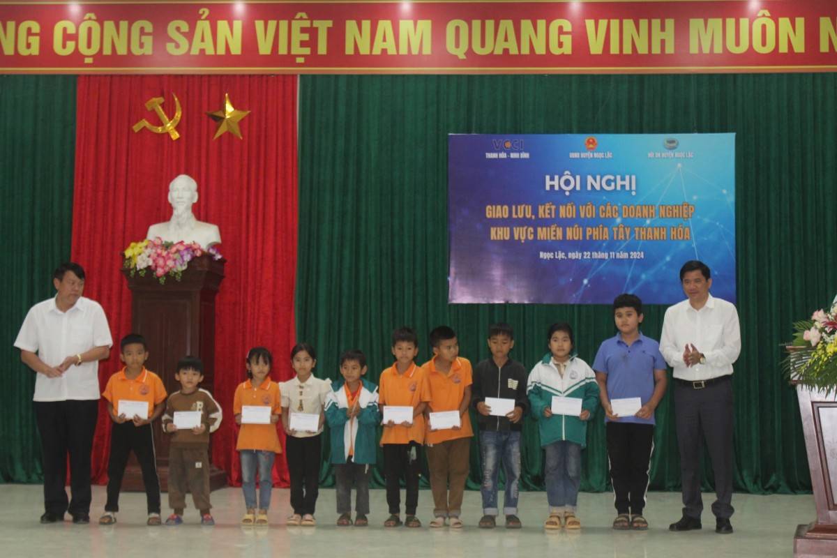 Đại diện lãnh đạo VCCI Thanh Hoá và lãnh đạo huyện Ngọc Lặc trao quà cho học sinh nghèo