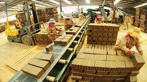 Công nhân làm việc trong dây chuyền sản xuất gạch ngói