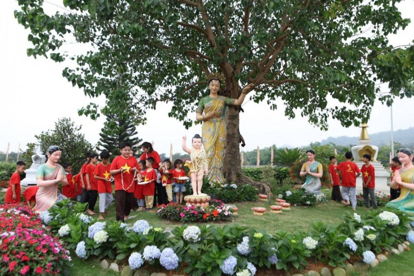  Các em thiếu nhi dâng hoa cúng tại vườn Phật đản sinh.