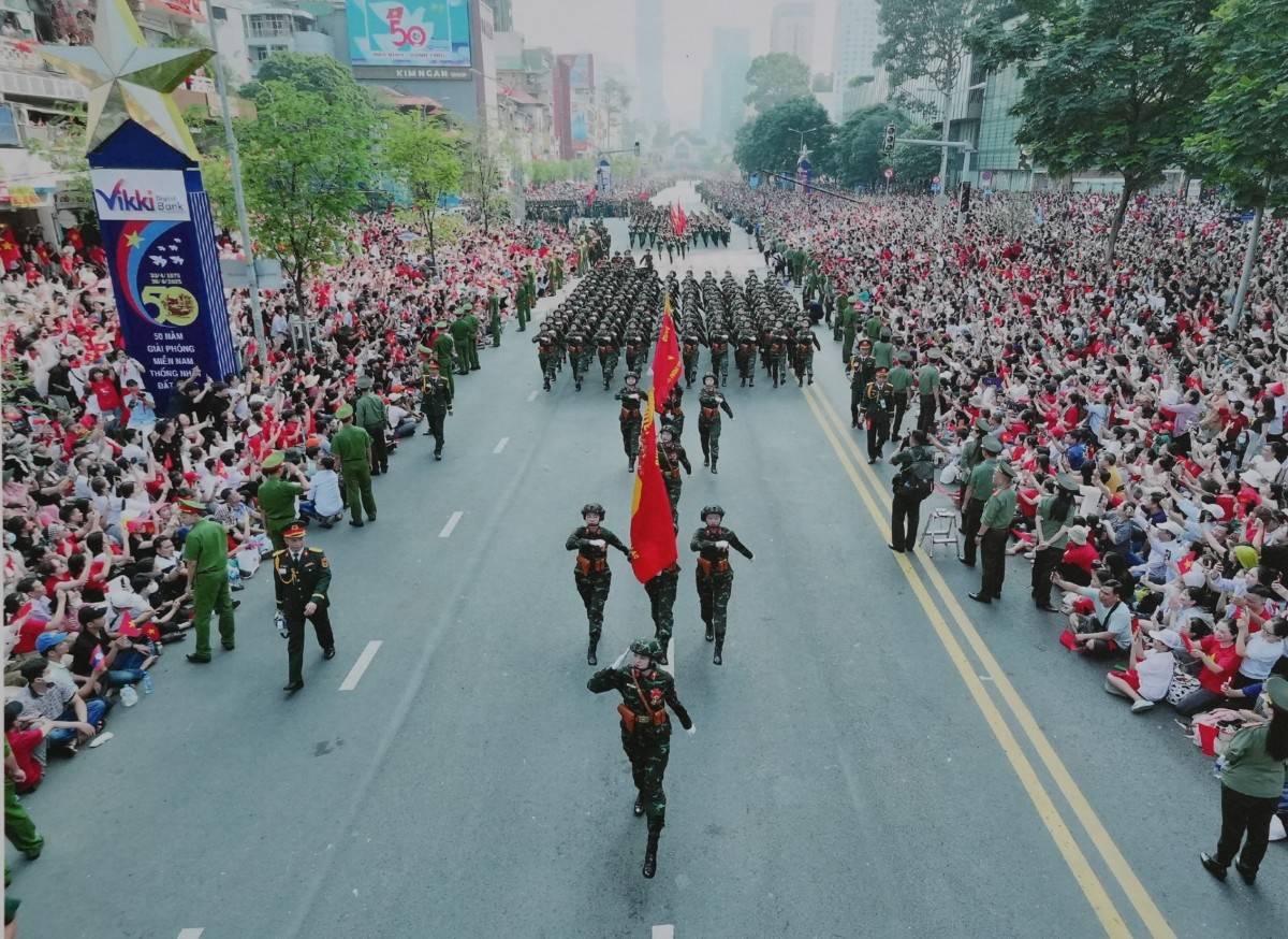 Khu vực trung tâm TP. Hồ Chí Minh rực màu cờ đỏ sao vàng với hàng vạn người dân từ mọi miền tổ quốc hân hoan đón chào các đoàn diễu binh, diễu hành nhân Kỷ niệm 50 năm Ngày Giải phóng miền Nam. (Ảnh được trưng bày tại triển lãm).