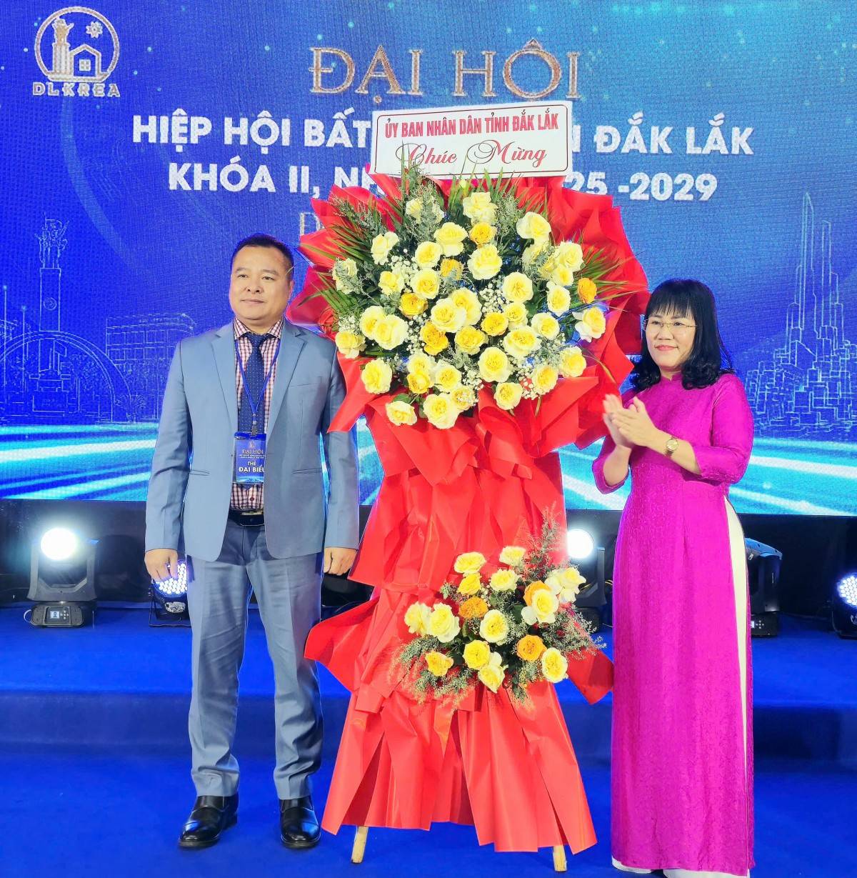 Ông Nguyễn Văn Kế, Chủ tịch Hiệp hội BĐS tỉnh Đắk Lắk khóa I nhận hoa chúc mừng đại hội từ bà Hồ Thị Nguyên Thảo.