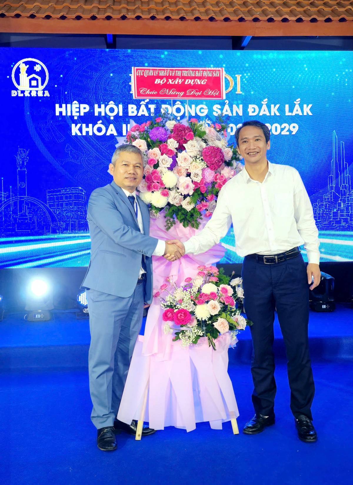 Ông Lê Thế Quân, Phó chủ tịch Hiệp hội BĐS tỉnh Đắk Lắk khóa I nhận hoa chúc mừng đại hội từ ông Vương Duy Dũng, Phó Cục trưởng Cục Quản lý Nhà và Thị trường BĐS Bộ Xây dựng.  