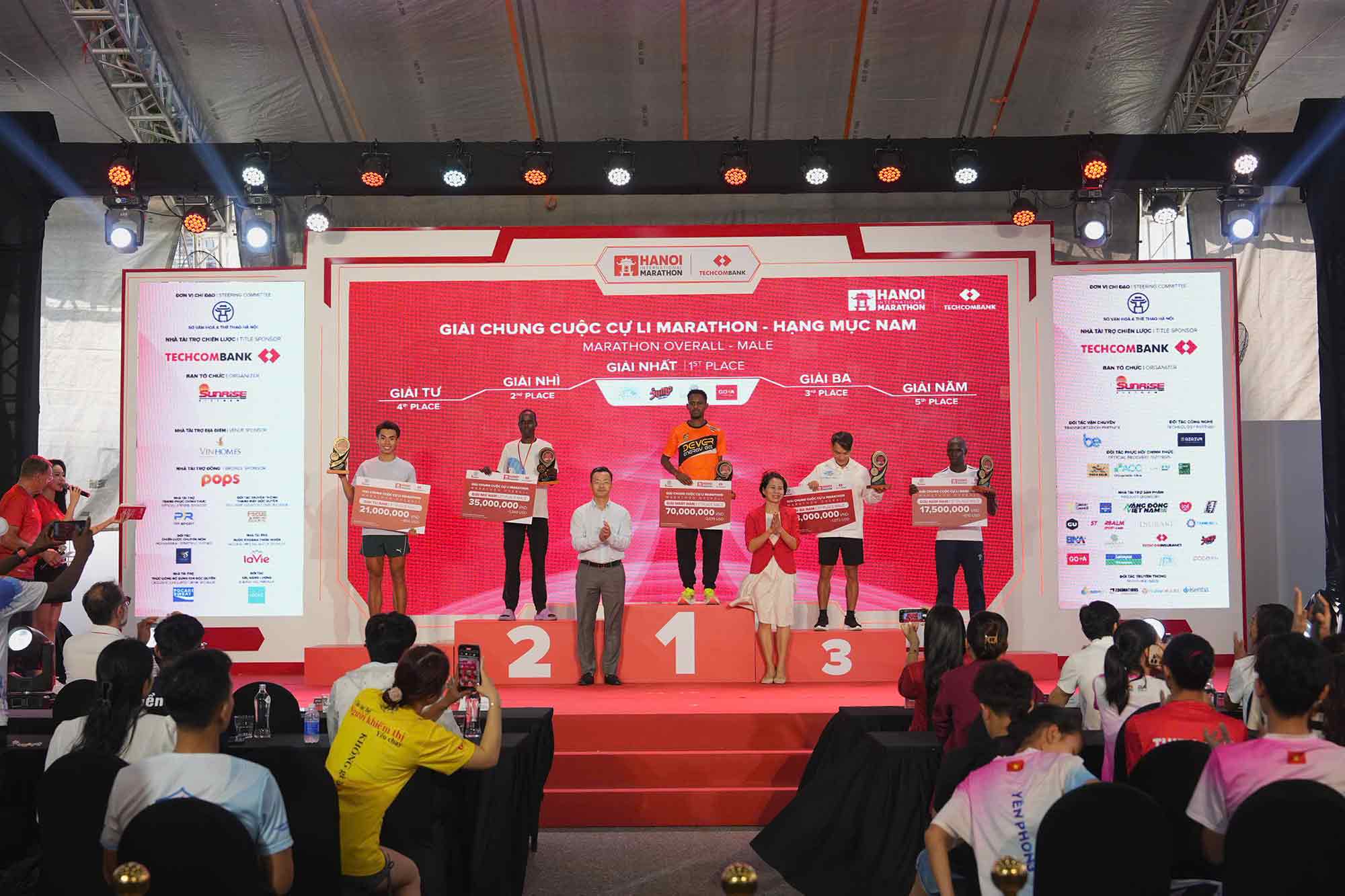 Bà Lê Thị Hoàng Yến- Phó Cục trưởng cục Thể dục thể thao và ông Phạm Xuân Tài- Phó giám đốc Sở Văn hoá và thể thao TP Hà Nội trao giải cho các VĐV xuất sắc đường đua marathon nam. Ảnh: Techcombank