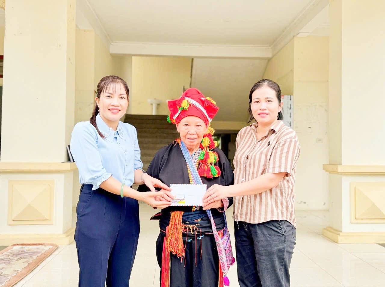 Bà Triệu Thị Lai (giữa) – người Dao đỏ, 74 tuổi, trao toàn bộ số tiền tiết kiệm của mình để ủng hộ công tác khắc phục hậu quả sau lũ tại xã Châu Quế, huyện Văn Yên, tỉnh Lào Cai.