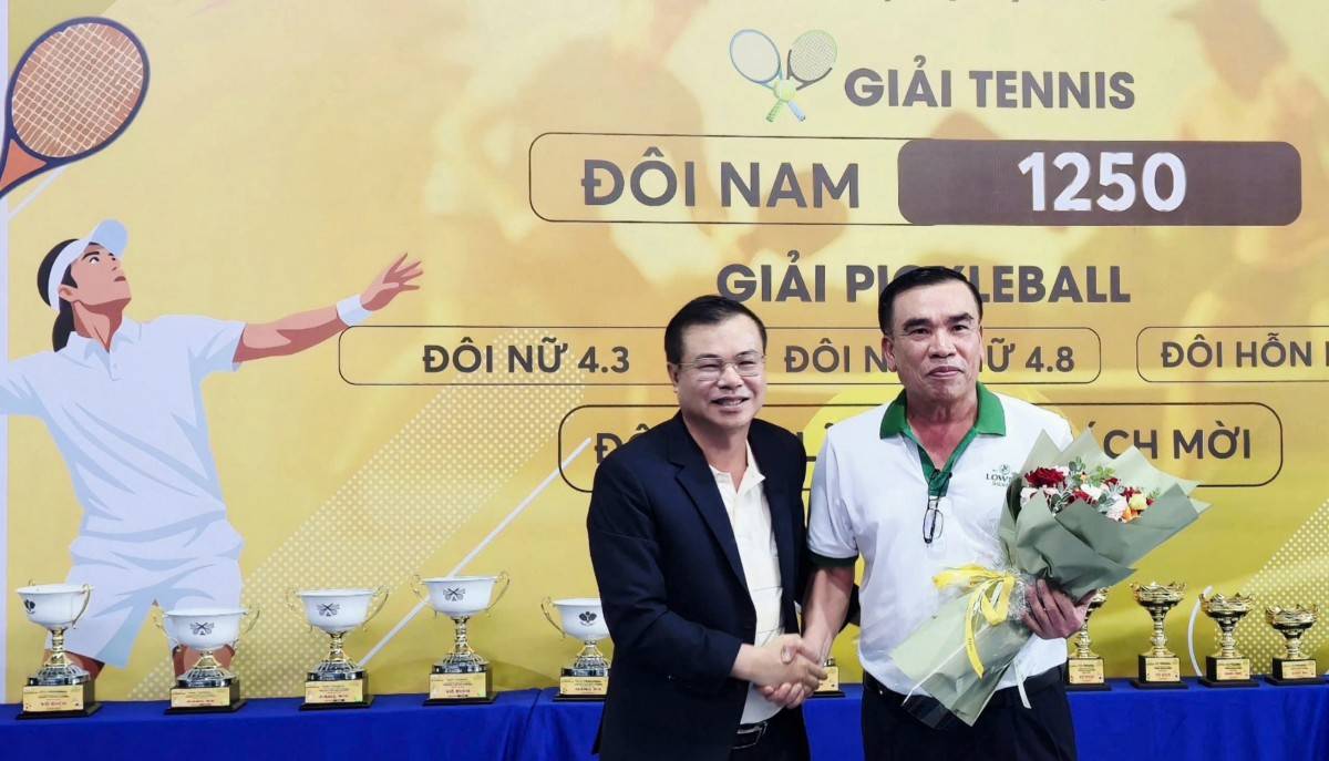 Ông Võ Thành Điền, Phó tổng giám đốc Công ty cổ phần Bia Sài Gòn - Miền Trung (nhãn hàng Bia Lowen) đại diện nhà tài trợ giải nhận hoa chúc mừng từ ông Nguyễn Huỳnh Vĩnh Huy (mặc áo đen), Chủ tịch Hội Doanh nhân trẻ tỉnh Đắk Lắk. 