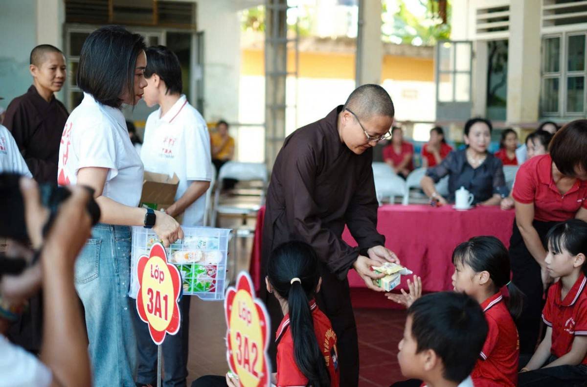 Các em học sinh nhận đồ thực phẩm sữa, bánh...