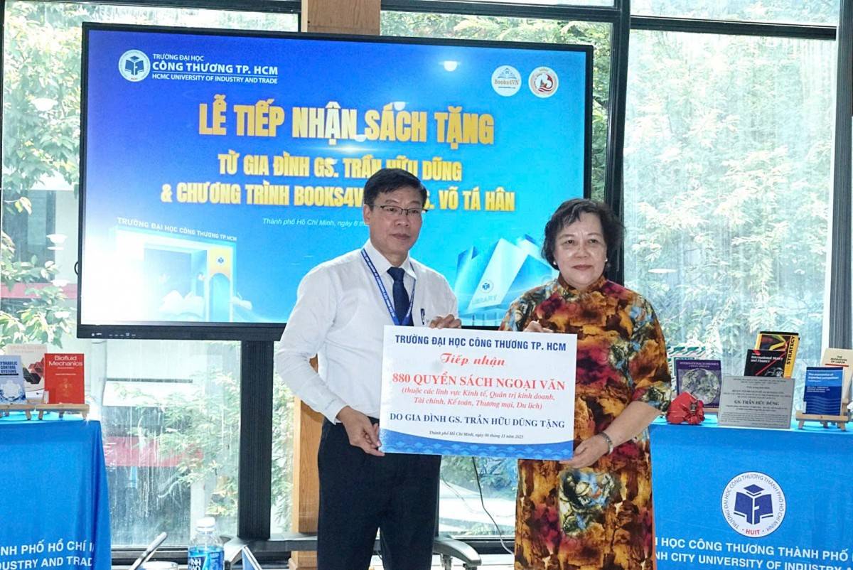 PGS.TS Nguyễn Xuân Hoàn, Hiệu trưởng Trường Đại học Công thương nhận những quyển sách từ đại diện gia đình cố GS. Trần Hữu Dũng.