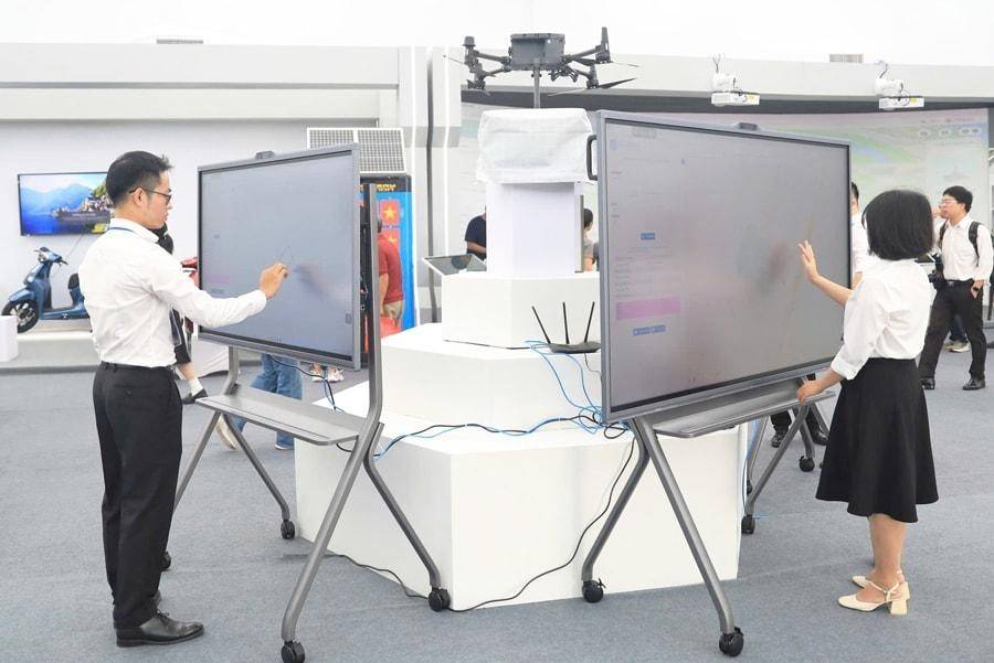 Khách trải nghiệm sản phẩm công nghệ trong Không gian Truyền thống và Sáng tạo Hà Nội 2025 tại Triển lãm Thành tựu kinh tế - xã hội.