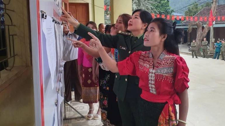 Cán bộ Đồn Biên phòng Tam Hợp, Ban Chỉ huy Bộ đội Biên phòng tỉnh Nghệ An hướng dẫn cử tri tìm hiểu tiểu sử và quá trình công tác của ứng cử viên.