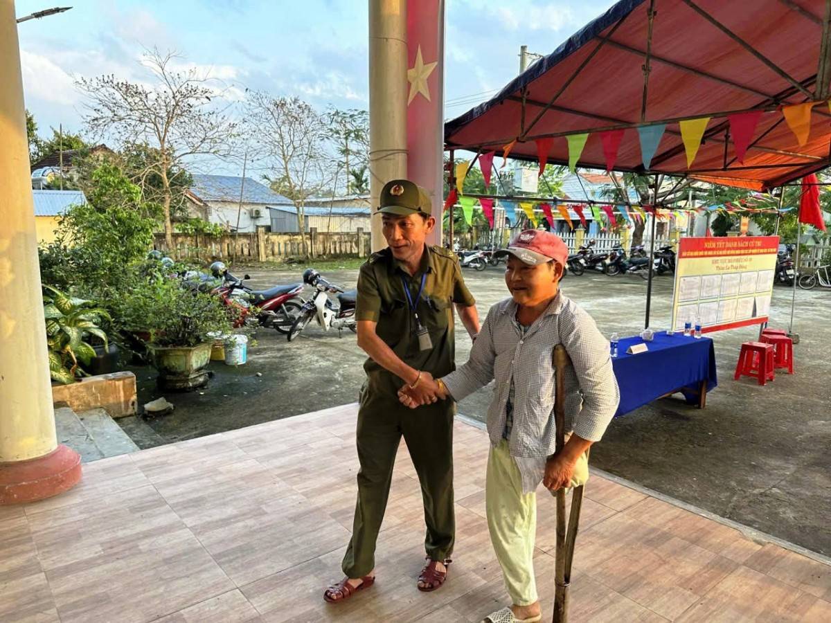 Lực lượng chức năng xã Thu Bồn hỗ trợ cử tri khuyết tật tham gia bỏ phiếu