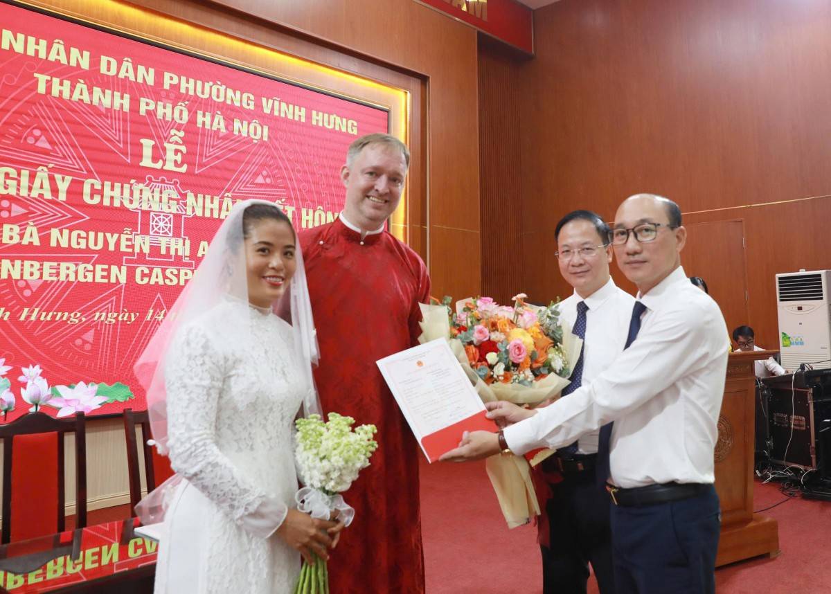 Lãnh đạo phường Vĩnh Hưng tặng hoa và trao Giấy chứng nhận kết hôn cho bà Nguyễn Thị Anh Vân và ông Steenbergen Casper Bessel Roelof, chuyên gia cao cấp của VinFast