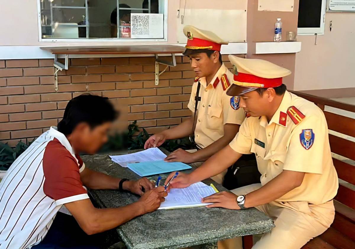 Lái xe Đ.V.L ký vào biên bản vi phạm hành chính khi làm việc với CSGT.
