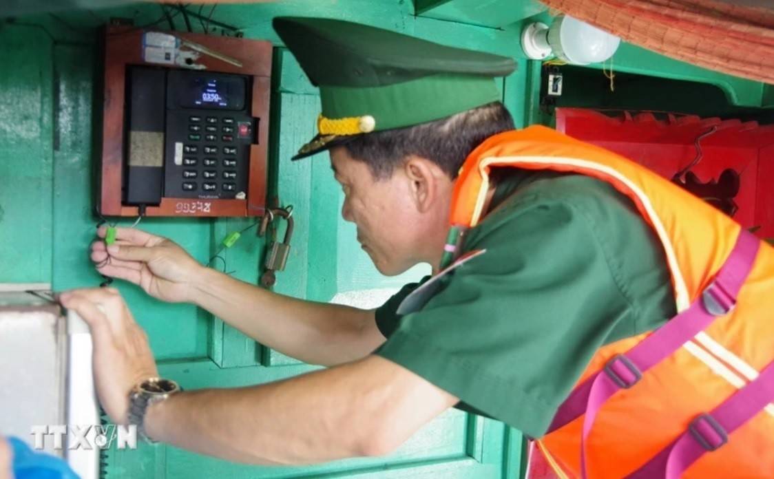Lực lượng biên phòng kiểm tra niêm phong, kẹp chì thiết bị giám sát hành trình VMS trước khi tàu cà xuất bến đánh bắt hải sản trên biển. Ảnh: TTXVN