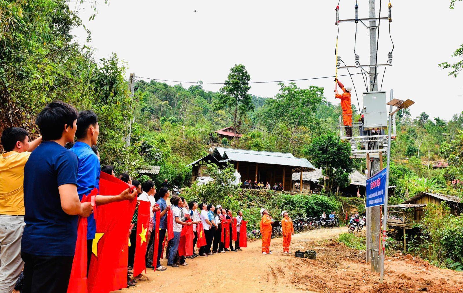 bà con bản Tia Ma Mủ hướng về phía cột điện cao thế - nơi những dòng điện đầu tiên sắp chảy vào từng nếp nhà. (Ảnh: Hà Dũng)