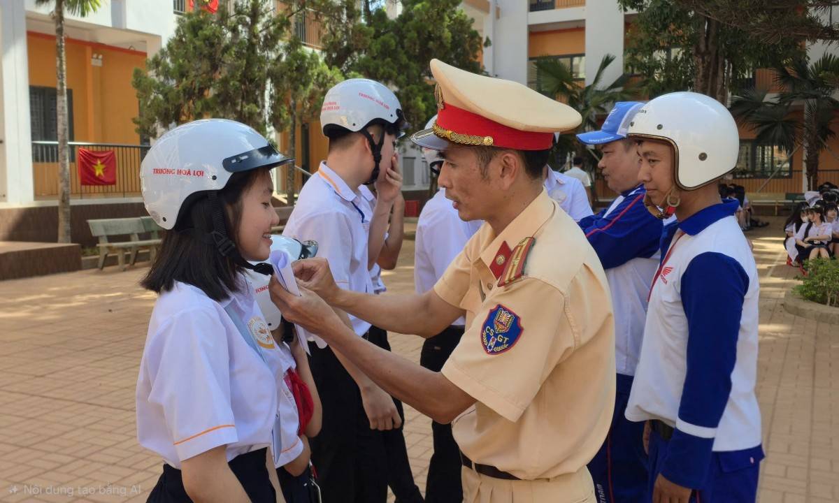 Cán bộ tổ CSGT địa bàn Buôn Ma Thuột hướng dẫn học sinh đội mũ bảo hiểm đúng cách.