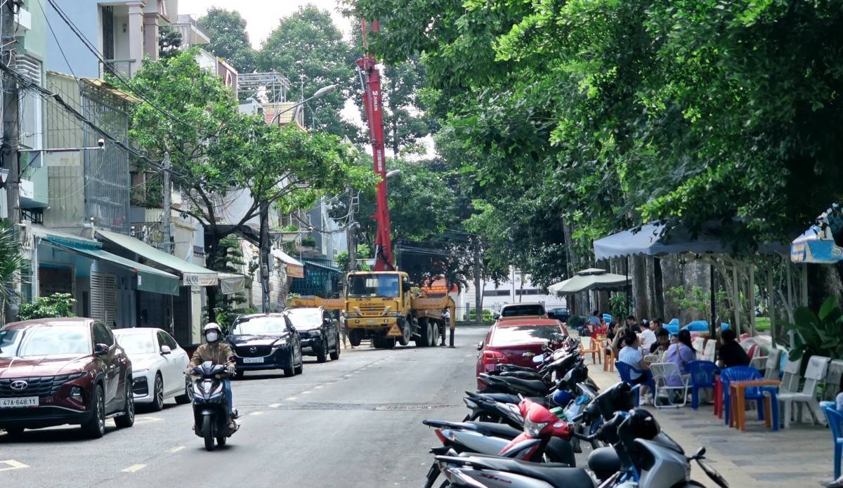  Xe của Công ty Bê tông Thành Công dừng đỗ đổ bê tông ngay khi lòng, lề đường Hoàng Văn Thụ bị chiếm dụng để xe mô tô, xe gắn máy và nơi ngồi uống cà phê.