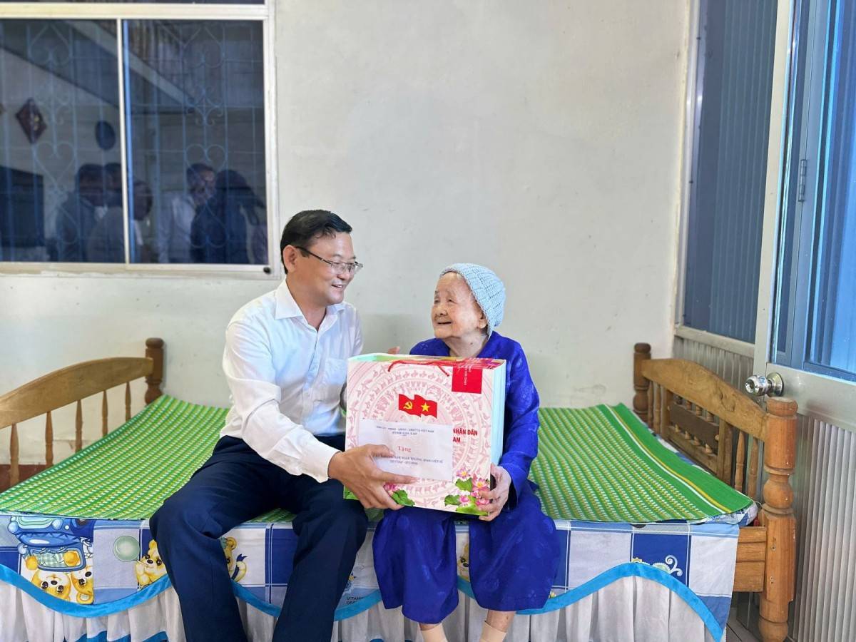 Phó Chủ tịch UBND tỉnh Nguyễn Tự Công Hoàng (bên trái) thăm hỏi, trao quà tri ân bà Trương Thị Kiều, vợ liệt sĩ.