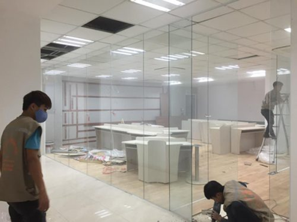 Kỹ thuật viên lắp đặt vách kính văn phòng cho khách hàng.