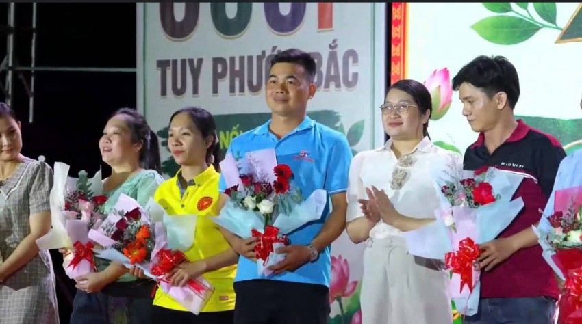 Bà Huỳnh Thị Thanh Nguyệt, Bí thư Đảng ủy, Chủ tịch HĐND xã Tuy Phước Bắc, tặng hoa các doanh nghiệp, hộ kinh doanh tham gia gian hàng tại phiên chợ.
