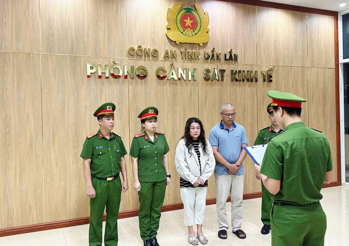 Vợ chồng bà Võ Thị Kim Thúy và ông Dương Hồng Sơn (mặc thường phục) nghe Công an tống đạt quyết định khởi tố bị can (Ảnh: Công an tỉnh Đắk Lắk).