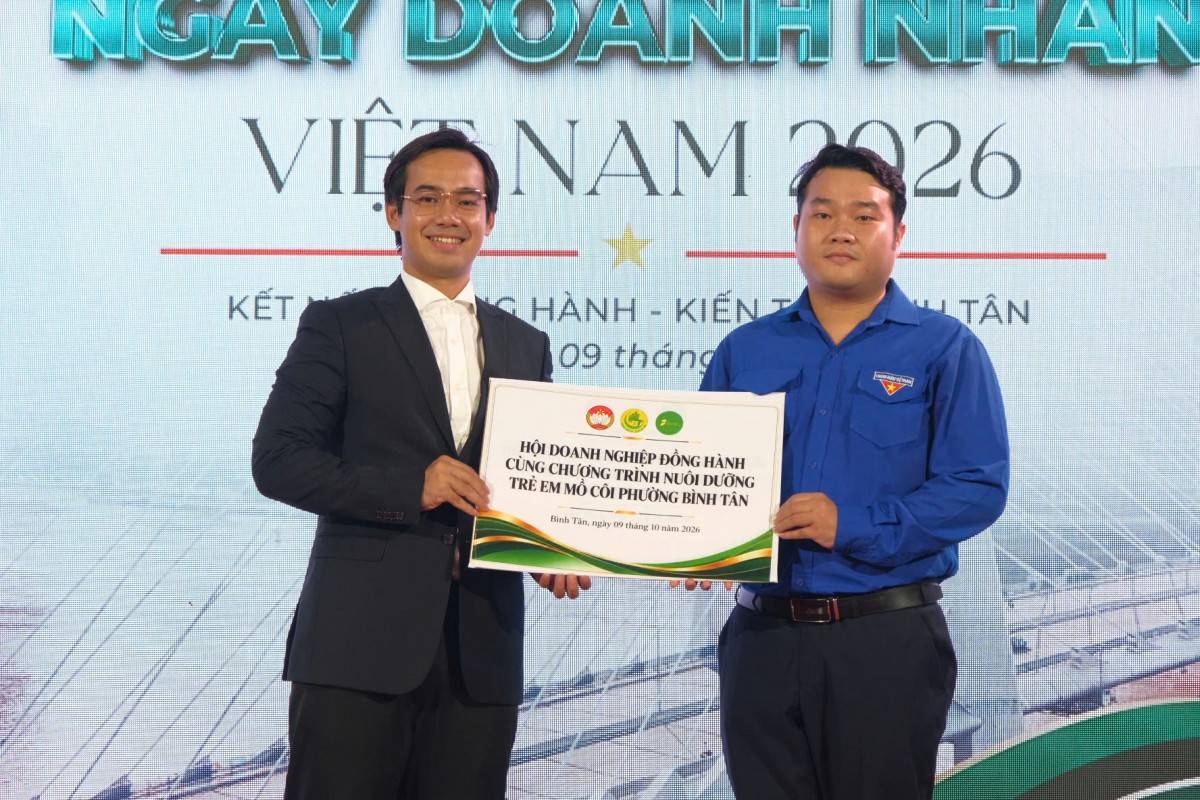 Ông Lê Văn Chí Huy - Chủ tịch Hội Doanh nghiệp phường Bình Tân tiến lên sân khấu để trao bảng biểu trưng “Hội doanh nghiệp đồng hành cùng chương trình nuôi dưỡng trẻ em mồ côi phường Bình Tân”.