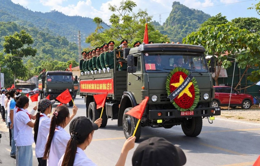 Đoàn xe đưa hài cốt liệt sĩ về Nghĩa trang Liệt sĩ quốc gia Vị Xuyên, người dân và học sinh đứng hai bên đường đón