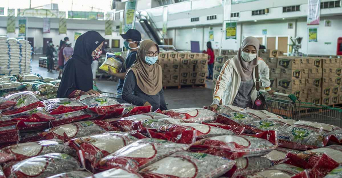 Người d&amp;acirc;n chọn mua gạo gi&amp;aacute; rẻ v&amp;agrave; c&amp;aacute;c mặt h&amp;agrave;ng tạp h&amp;oacute;a kh&amp;aacute;c tại một nh&amp;agrave; kho trong bối cảnh b&amp;ugrave;ng ph&amp;aacute;t dịch Covid-19, ở Surabaya, Đ&amp;ocirc;ng Java, Indonesia