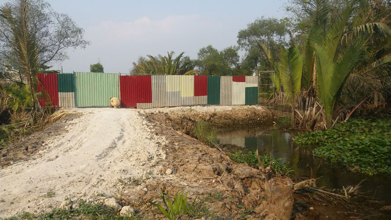 Lô đất đã lấn chiếm một phần kênh rạch và được làm đường đi vào có rào chắn bằng tôn và lưới kẽm. Lô đất đã lấn chiếm một phần kênh rạch và được làm đường đi vào có rào chắn bằng tôn và lưới kẽm.