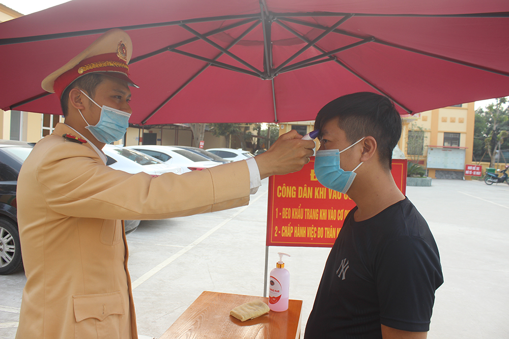 C&amp;aacute;c chi&amp;ecirc;n sĩ CSGT c&amp;ocirc;ng an tỉnh Ph&amp;uacute; Thọ kiểm tra th&amp;acirc;n nhiệt cho người d&amp;acirc;n khi đến trụ sở C&amp;ocirc;ng an l&amp;agrave;m việc