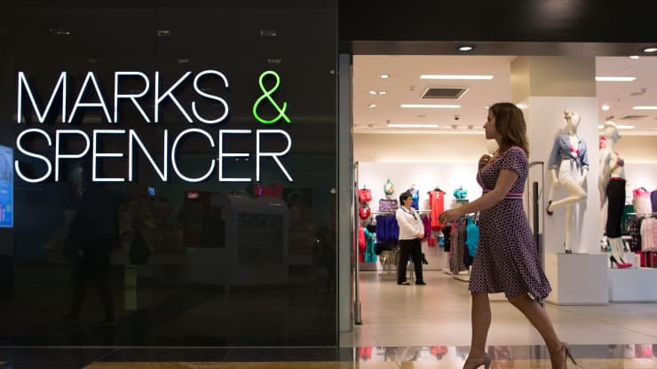 Một du kh&amp;aacute;ch đi ngang qua lối v&amp;agrave;o Marks &amp;amp; Spencer Plcstore trong khu phức hợp mua sắm v&amp;agrave; giải tr&amp;iacute; Afimall City tại trung t&amp;acirc;m thương mại &amp;ldquo;Th&amp;agrave;nh phố Moscow&amp;rdquo; ở Moscow, Nga, v&amp;agrave;o thứ S&amp;aacute;u, ng&amp;agrave;y 17 th&amp;aacute;ng 5 năm 2013.