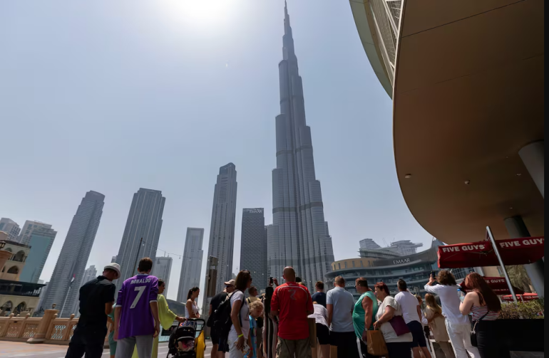 Kh&amp;aacute;ch du lịch tụ tập để ngắm nh&amp;igrave;n t&amp;ograve;a nh&amp;agrave; Burj Khalifa ở Dubai. Chris Whiteoak / Quốc gia