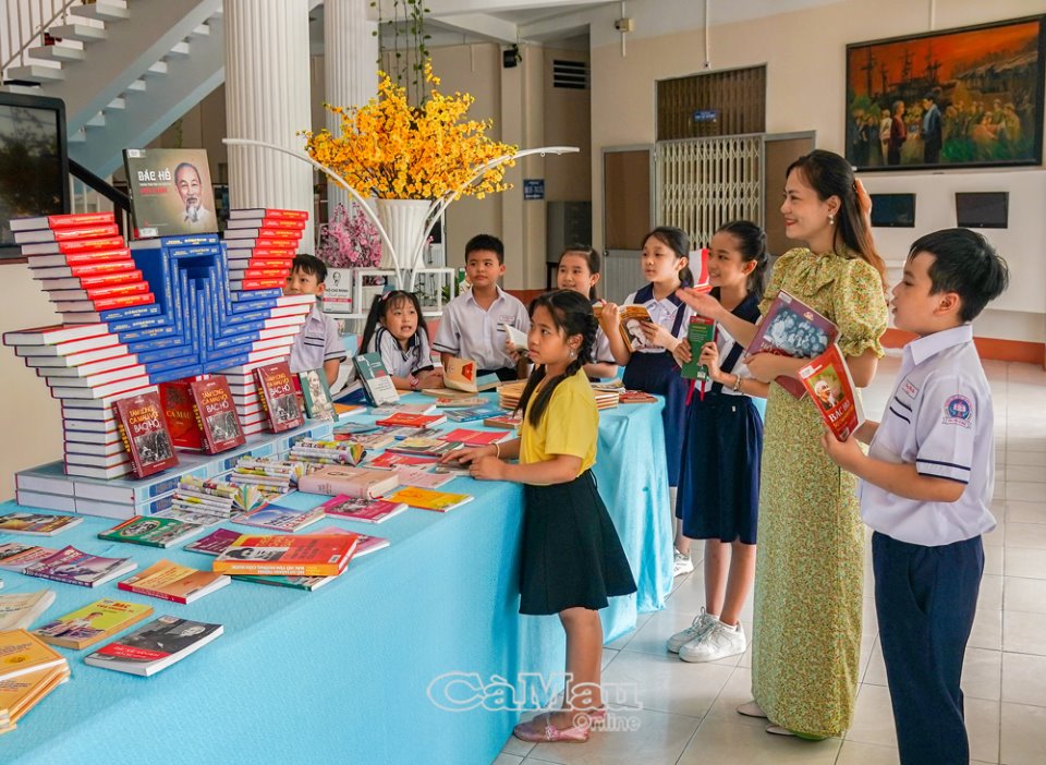 Thư viện tỉnh tổ chức trưng b&amp;agrave;y s&amp;aacute;ch, b&amp;aacute;o về Chủ tịch Hồ Ch&amp;iacute; Minh, thu h&amp;uacute;t nhiều bạn đọc đến tham quan, t&amp;igrave;m hiểu về cuộc đời v&amp;agrave; sự nghiệp c&amp;aacute;ch mạng của Người. (Trong ảnh: Chị Nguyễn Hằng Ni hướng dẫn c&amp;aacute;c em học sinh trường Tiểu học Quang Trung, TP C&amp;agrave; Mau tham quan khu trưng b&amp;agrave;y)