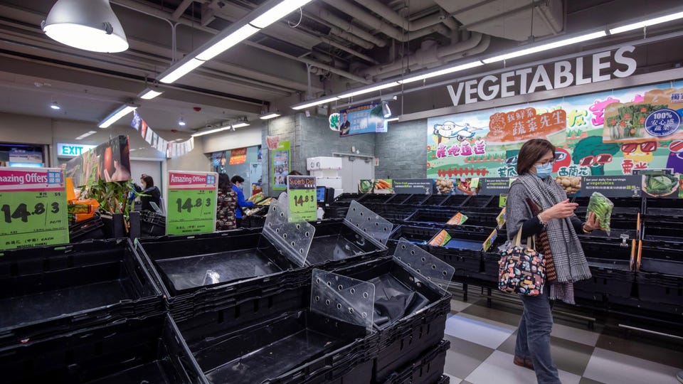 Những người mua sắm dọn sạch c&amp;aacute;c kệ h&amp;agrave;ng của một si&amp;ecirc;u thị ở Hồng K&amp;ocirc;ng v&amp;agrave;o ng&amp;agrave;y 8 th&amp;aacute;ng 2 năm 2022. PAUL YEUNG / BLOOMBERG