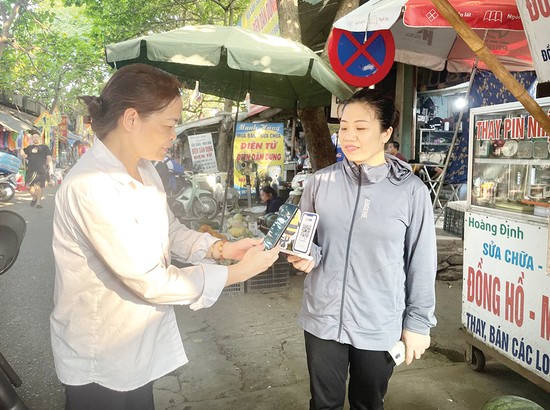 Người d&amp;acirc;n mua h&amp;agrave;ng thanh to&amp;aacute;n qua qu&amp;eacute;t m&amp;atilde; QR tr&amp;ecirc;n ứng dụng Mobile Banking của ng&amp;acirc;n h&amp;agrave;ng
