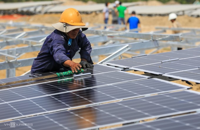 C&amp;ocirc;ng nh&amp;acirc;n vệ sinh c&amp;aacute;c tấm pin năng lượng mặt trời tại một dự &amp;aacute;n ở Ninh Thuận. Ảnh: Quỳnh Trần