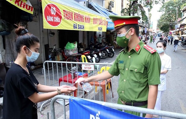 Người d&amp;acirc;n v&amp;agrave;o mua đồ thiết yếu tại chợ Đồng Xu&amp;acirc;n được lực lượng chức năng y&amp;ecirc;u cầu rửa tay s&amp;aacute;t khuẩn