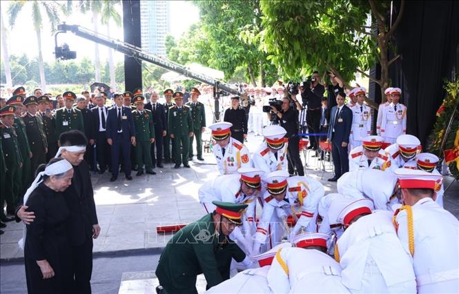 Gia đ&amp;igrave;nh c&amp;ugrave;ng c&amp;aacute;c đại biểu chứng kiến Đội nghi lễ tiến h&amp;agrave;nh hạ huyệt linh cữu Tổng B&amp;iacute; thư Nguyễn Ph&amp;uacute; Trọng. Ảnh: TTXVN