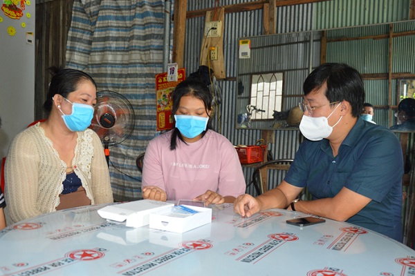 Em Nguyễn Thị Minh Thư nhận máy tính bảng từ Bí thư Tỉnh uỷ Đồng Tháp. (Ảnh: Nhựt An ) Em Nguyễn Thị Minh Thư nhận máy tính bảng từ Bí thư Tỉnh uỷ Đồng Tháp. (Ảnh: Nhựt An )