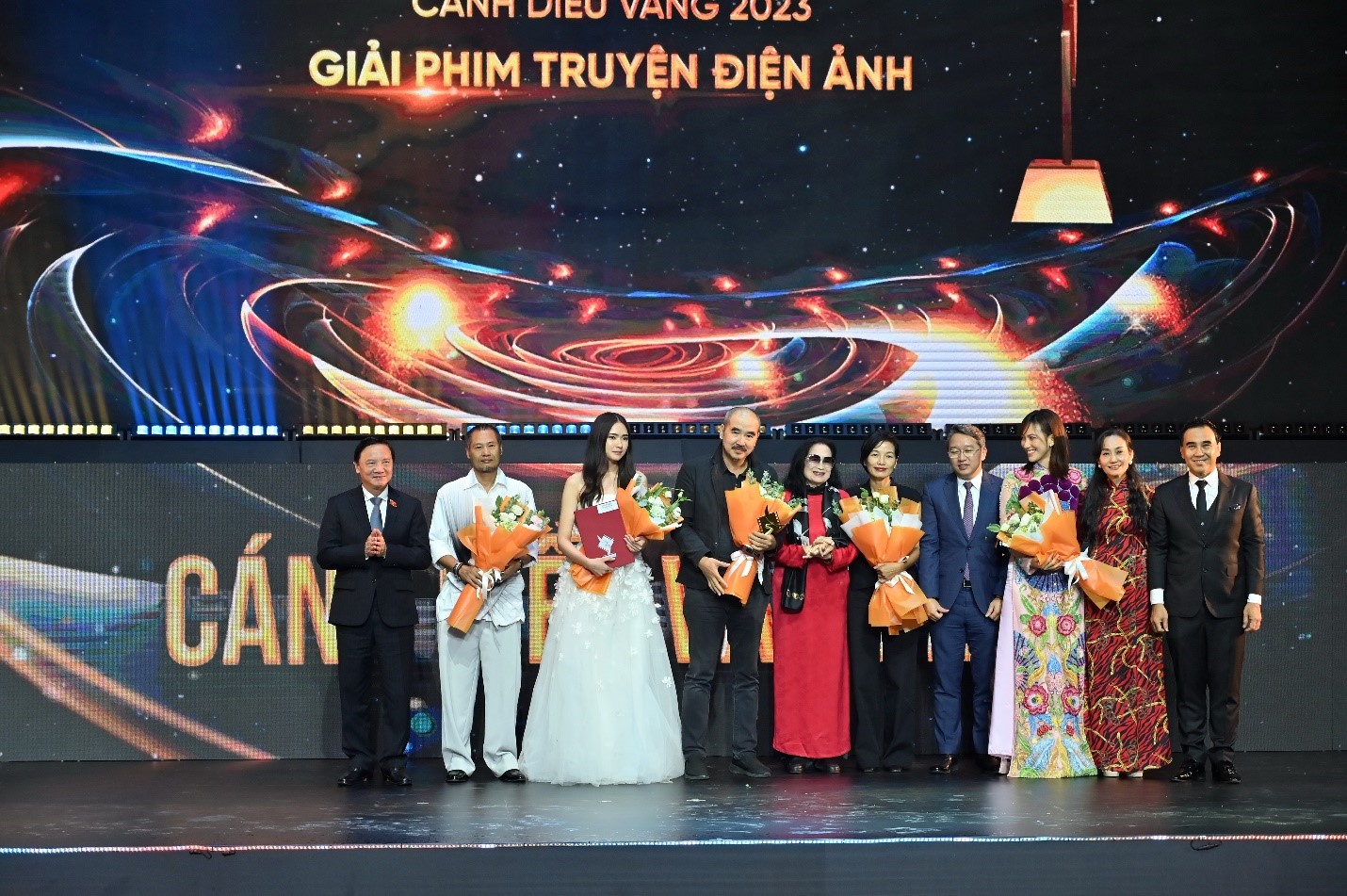 &amp;Ocirc;ng Khắc Định- Ph&amp;oacute; Chủ Tịch Quốc Hội, (b&amp;igrave;a tr&amp;aacute;i) &amp;Ocirc;ng Nguyễn Hải Ninh &amp;ndash; B&amp;iacute; Thư Tỉnh Ủy Kh&amp;aacute;nh H&amp;ograve;a (thứ tư, b&amp;igrave;a phải) trao giải Phim truyện điện ảnh v&amp;agrave; c&amp;aacute;c NS ch&amp;uacute;c mừng Giải thưởng C&amp;aacute;nh diều v&amp;agrave;ng d&amp;agrave;nh cho Phim truyện điện ảnh xuất sắc nhất năm 2023 thuộc về &amp;ldquo;Tro t&amp;agrave;n rực rỡ&amp;rdquo; của đạo diễn B&amp;ugrave;i Thạc Chuy&amp;ecirc;n