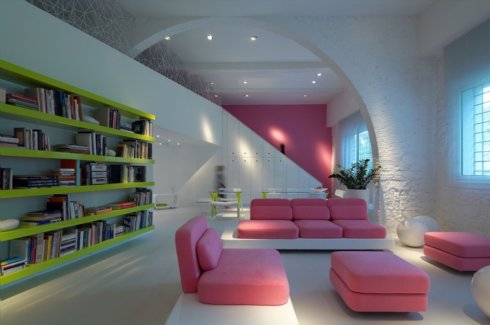 Sự kết hợp giữa ba m&amp;agrave;u: tường m&amp;agrave;u trắng, kệ s&amp;aacute;ch m&amp;agrave;u xanh l&amp;aacute; c&amp;acirc;y v&amp;agrave; bộ sofa m&amp;agrave;u hồng tạo n&amp;ecirc;n sự tương phản cao cho ph&amp;ograve;ng kh&amp;aacute;ch th&amp;ecirc;m hiện đại.