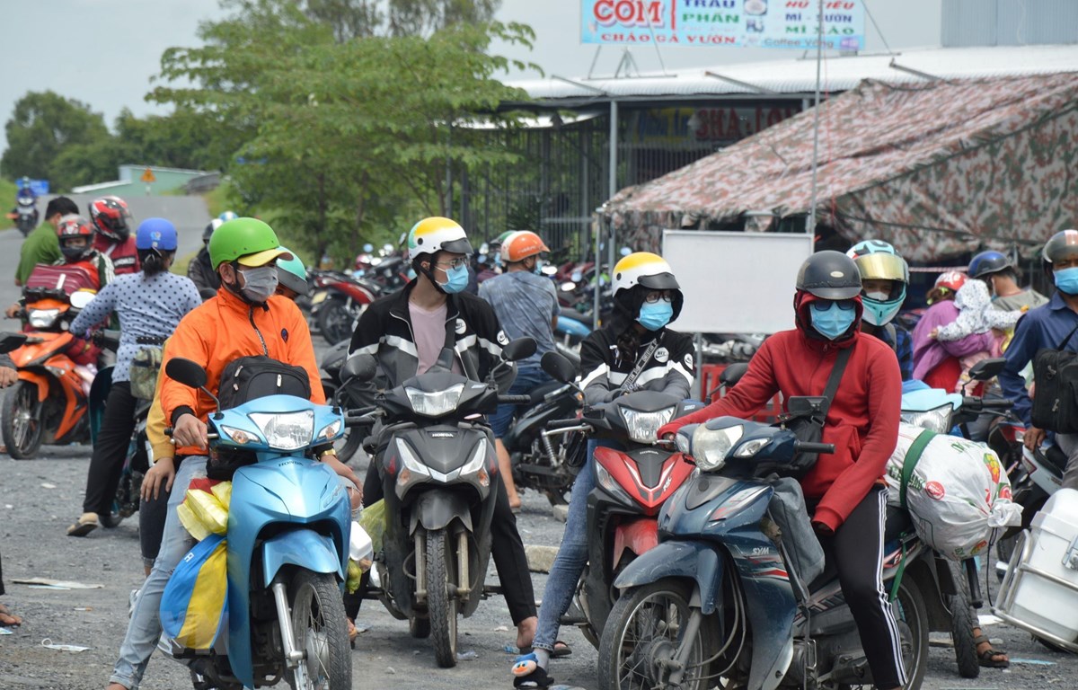 Người d&amp;acirc;n Đồng Th&amp;aacute;p về từ c&amp;aacute;c tỉnh tại điểm tiếp nhận, x&amp;eacute;t nghiệm s&amp;agrave;ng lọc SARS-CoV-2 tr&amp;ecirc;n Quốc lộ N2 (x&amp;atilde; Đốc Binh Kiều, huyện Th&amp;aacute;p Mười). (Ảnh: Nhựt An/TTXVN)