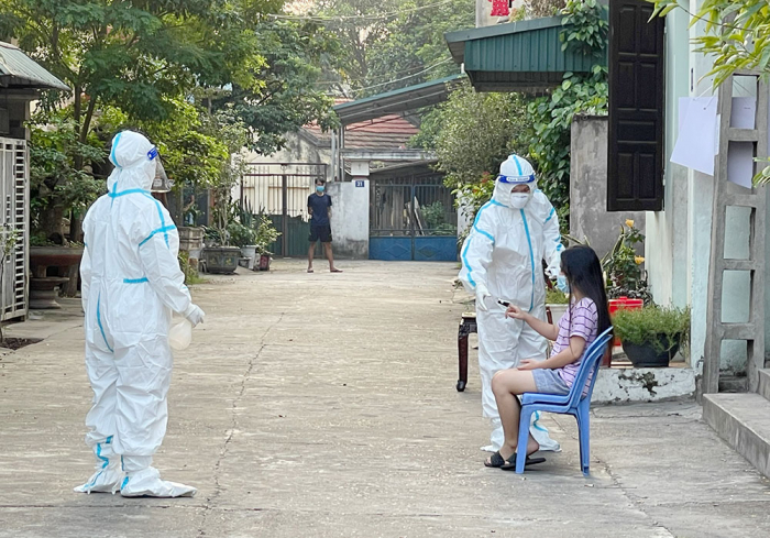 Nh&amp;acirc;n vi&amp;ecirc;n y tế kiểm tra sức khỏe cho người d&amp;acirc;n trong khu vực phong tọa