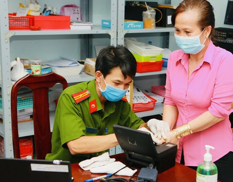 C&amp;aacute;n bộ CS C&amp;ocirc;ng an TP.HCM thực hiện lấy dấu v&amp;acirc;n tay cho người d&amp;acirc;n. Ảnh: Đức Nam.