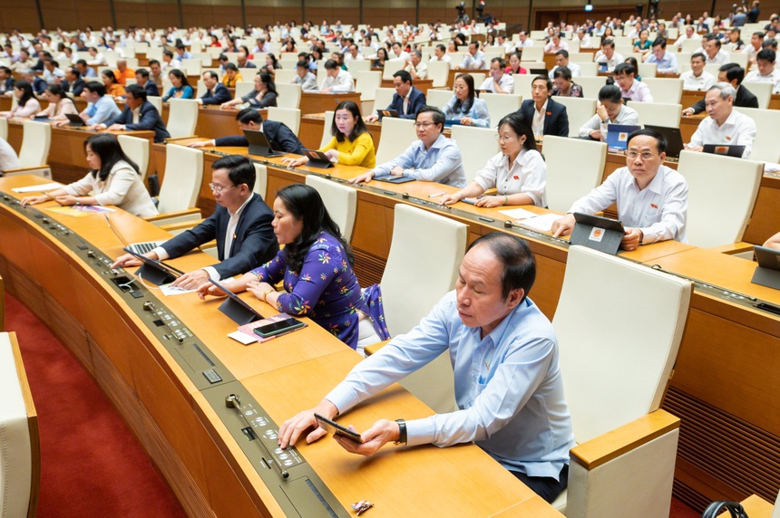 C&amp;aacute;c đại biểu Quốc hội bấm n&amp;uacute;t th&amp;ocirc;ng qua Nghị quyết về th&amp;iacute; điểm đấu gi&amp;aacute; biển số &amp;ocirc;t&amp;ocirc;. Ảnh: Phạm Thắng.