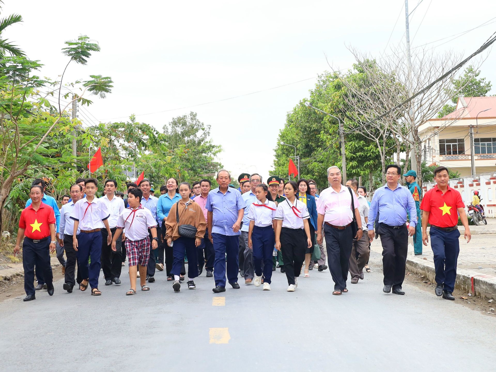 C&amp;aacute;c đại biểu, nh&amp;acirc;n d&amp;acirc;n v&amp;agrave; c&amp;aacute;c em học sinh đi tr&amp;ecirc;n c&amp;ocirc;ng tr&amp;igrave;nh &amp;ldquo;Đường cờ Tổ quốc&amp;rdquo; tại huyện Phong Điền.